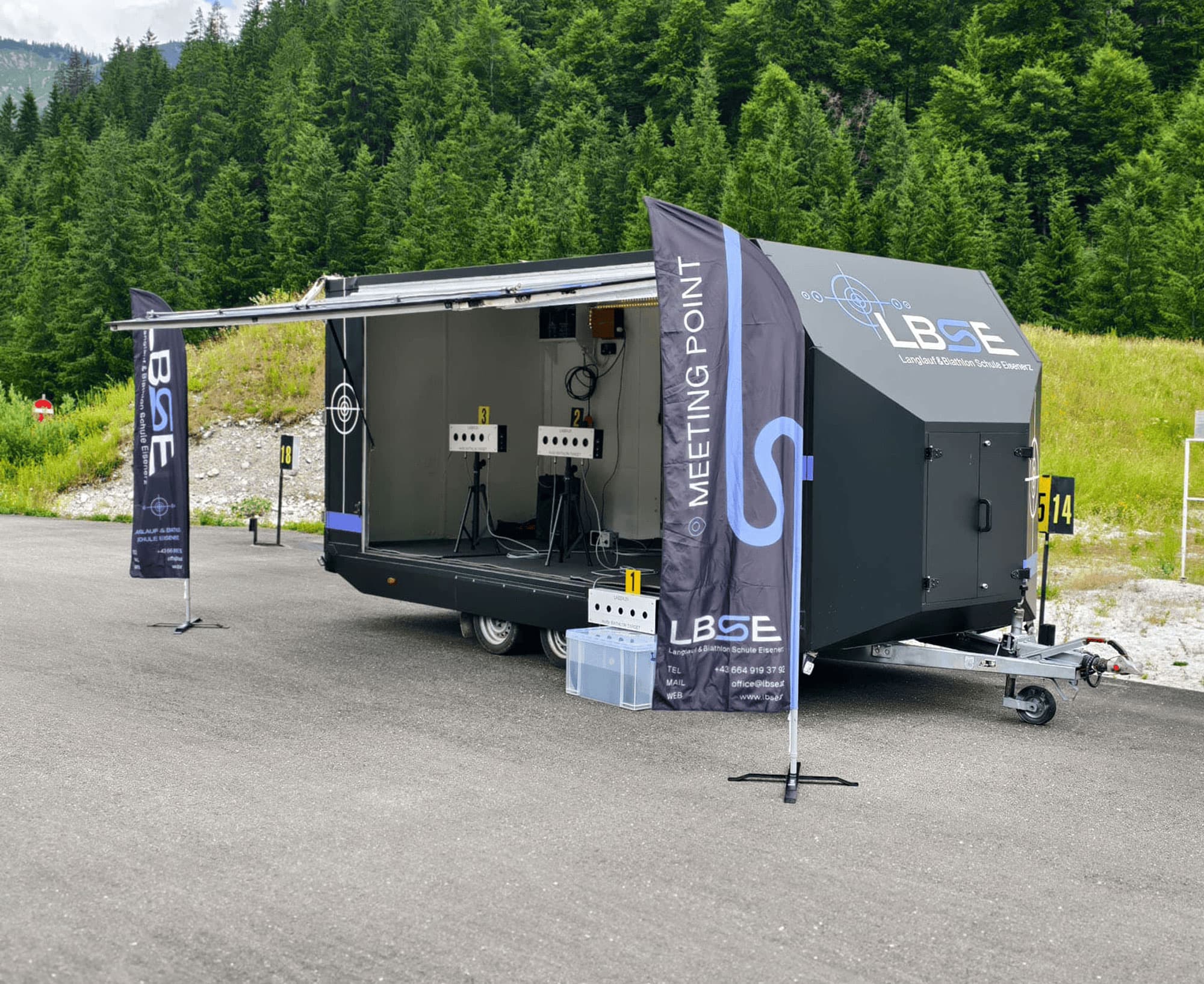 Mobile Langlaufschule mit Biathlon-Schießstand und Lasergewehren. Bild vom Anhänger wo die Zielscheiben drinnen sind